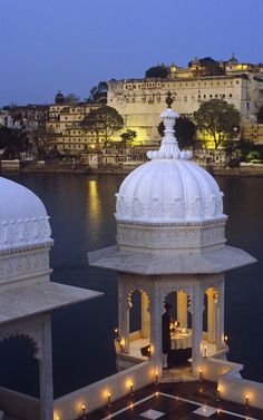 two white gazebos sitting next to each other in front of a body of water