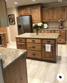 a large kitchen with granite counter tops and wooden cabinetry, along with stainless steel appliances