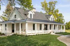 a white house sitting on top of a lush green field