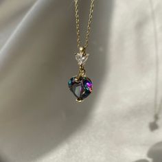 This necklace is an exquisite piece of jewelry that will add a touch of elegance to any outfit. The pendant is made of alexandrite, a unique gemstone that changes color depending on the lighting. The heart-shaped pendant is a beautiful multicolor that sparkles in the light. The pendant is set in a delicate gold chain that adds to the overall dainty look of the necklace. Alexandrite is the birthstone for June, making this necklace an ideal gift for anyone born in that month. It would also make a Heart Shaped Jewel Necklace For Wedding, Elegant Crystal Necklace With Heart Charm, Elegant Crystal Heart Pendant Necklace, Elegant Heart Shaped Crystal Clavicle Necklace, Elegant Crystal Heart Beads Necklace Gift, Elegant Heart-shaped Crystal Necklace, Elegant Multicolor Heart Cut Jewelry, Elegant Multicolor Valentine's Day Jewelry, Elegant Multicolor Necklace With Heart Charm