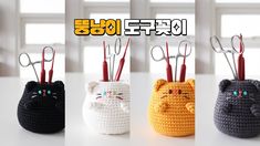 four small crocheted cats with scissors in their mouths are shown on a table