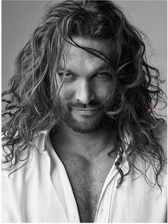 a black and white photo of a man with long hair