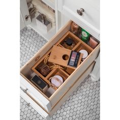 an open drawer in a bathroom with items inside