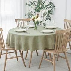 the table is set with four chairs and a vase filled with flowers on top of it