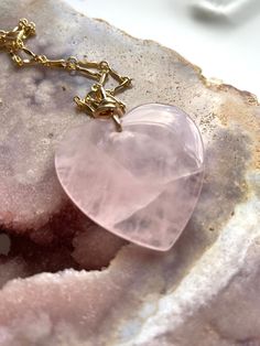 Pretty in pink. This large rose quartz crystal pendant necklace is the perfect healing piece to add to your jewelry collection. Exuding dusty soft shades of pink, rose quartz helps soothe your heart and emit love to those all around you. Embrace the delightful beauty and tranquil benefits of this gentle and graceful creation. Pink Rose Quartz Crystal Pendant Necklace• Beautifully polished raw rose quartz• Soft and feminine style• Loving calm energy — speaks directly to your heart chakra• 14K Gold filled chain about 16” 30x32 • Delivered in a luxurious pink velvet jewelry bagMANY ROSE QUARTZ BENEFITS • Unconditional love• Compassion and peace• Healing nourishment and comfort• Contentment to give and receive love• High spiritual attunement to the earth, universe, and the divine• Love in ones Pink Heart Gemstone Pendant Necklace, Delicate Pink Rose Quartz Crystal Necklace, Valentine's Day Rose Quartz Jewelry With Natural Stones, Delicate Pink Rose Quartz Necklace, Rose Quartz Heart Pendant Necklace With Charm, Pink Rose Quartz Crystal Necklace With Natural Stones, Spiritual Rose Quartz Necklace For Valentine's Day, Valentine's Day Pink Rose Quartz Jewelry, Pink Rose Quartz Gemstone Necklaces