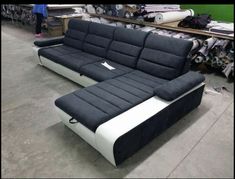 a black and white couch sitting on top of a floor next to a green wall