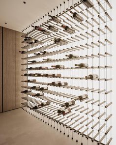 a room filled with lots of wine bottles hanging from the ceiling next to a wall