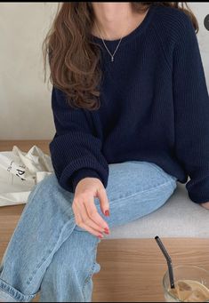 a woman sitting on the floor next to a cup of coffee and a straw in her hand