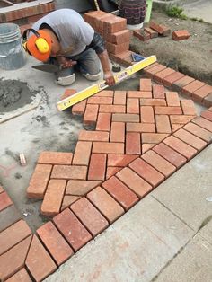 a man laying bricks on the ground