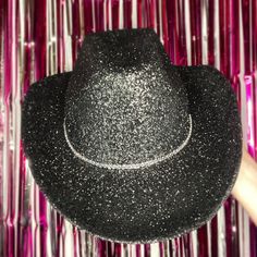 Black Glitter with Rhinestone Band Cowboy Hat. This cowboy hat is the perfect addition to your party, events, and even cute photos! This is an adult-sized, polyester cowboy hat sealed in glitter with a single rhinestone band. The glitter is only on the top of the hat ensuring that it will not get in your hair! The bottom of the hat is black matching the glitter color. The hat circumference is 23 inches. Keep in mind that this is not a fitted cowboy hat, one size fits most but it ranges on the la Black Sparkly Cowboy Hat, Black Glitter Cowboy Hat, Black Rhinestone Cowboy Hat, Western Black Costume Hats And Headpieces For Party, Western Adjustable Costume Hats For Parties, Western Curved Brim Costume Hat For Parties, Western Fedora Party Hat, Western Style Party Top Hat With Curved Brim, Western Style Top Hat With Curved Brim For Party