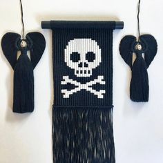 the skull and crossbones are hanging on the wall with tassels attached to it