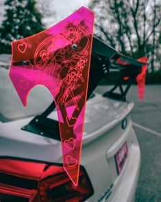 the tail end of a car that has been decorated with pink and red designs on it