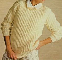 a woman is wearing a sweater and pants with her hands on her hips while posing for the camera