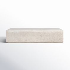 a block of concrete sitting on top of a white surface with no one around it