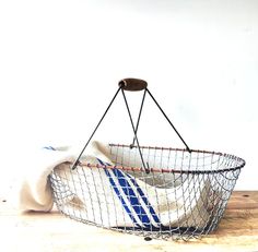 a basket that is sitting on top of a wooden table next to a white wall