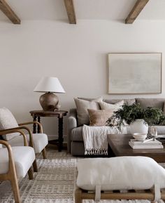 a living room filled with lots of furniture next to a painting on the wall and floor