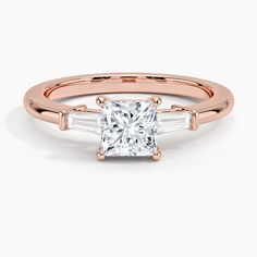 a rose gold engagement ring with two baguets on the band and a princess cut diamond