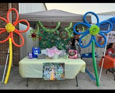 an outdoor table with flowers and decorations on it