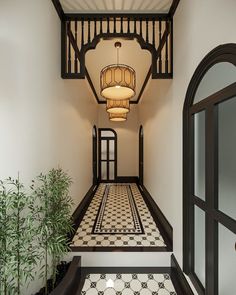 a hallway with black and white tile flooring and chandelier hanging from the ceiling