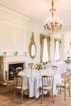 an elegant dining room with white table cloths and gold chairs