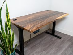 a wooden table sitting next to a potted plant