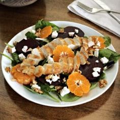 a white plate topped with salad and fruit