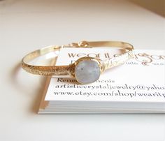 Moonstone Bangle Bracelet in Gold Filled, June Birthday Gift, Birthstone Jewelry, Personalized Gift for Bridesmaid, Friendship Bracelet ::THE DETAILS:: --This listing includes one bracelet, additional bracelets pictured are sold separately. --Will fit wrist sizes between 5.75 to 7 inches but may fit a bit snug on a 7 inch wrist. --This is my signature adjustable cuff-bangle bracelet. Sized for most everyone. --14kt Gold Filled textured bangle has a 4mm lip. --Bangle is approximately 16 gauge 14k Adjustable Gemstone Bangle For Wedding, Adjustable Moonstone Jewelry For Formal Occasions, Moonstone Wedding Bracelet Jewelry, Moonstone Wedding Bracelet, Handmade Bangle Bracelets, Gold Deposit, Sapphire Bangle, June Birthday, Filigree Pattern