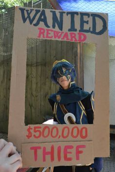 a cardboard sign that says wanted reward $ 500, 000 thief with a costume on