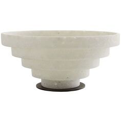 a white bowl sitting on top of a wooden stand