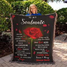 a woman holding up a blanket with the words to my soulmate and a rose on it