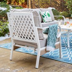 a white patio chair sitting on top of a blue rug