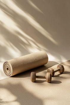 a yoga mat and two wooden rollers on top of a beige carpeted floor