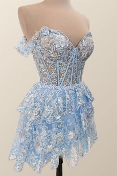 This blue, tulle A-line dress features a semi-sheer bodice with structured boning, off-the-shoulder styling, festive lace appliques, and a lace-up back closure for a chic mini silhouette. Off-shoulder Prom Dress With Corset Back, Light Blue Dress With Corset Back And Fitted Bodice, Blue Lace Party Corset Dress, Blue Lace Corset Dress For Party, Prom Mini Dress With Illusion Neckline, Blue Prom Dress With Boned Bodice, Blue Dresses With Boned Bodice For Prom, Blue Ruffles Fitted Bodice Mini Dress, Blue Mini Dress With Ruffles And Fitted Bodice