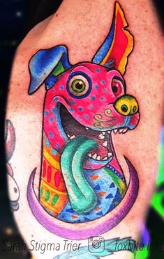 a colorful dog tattoo on the back of a woman's arm