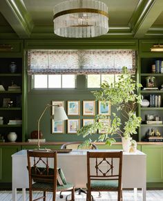 a dining room with green walls and furniture