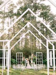 a bride and groom standing under an arch in the middle of their wedding ceremony venue