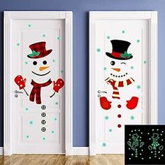 two snowmen with hats and scarfs are standing in front of the door