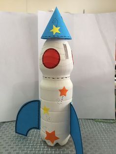 a paper model of a rocket ship with a blue hat on it's head