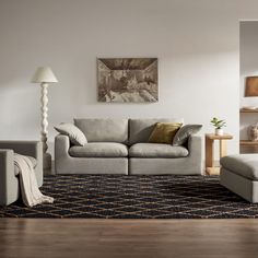 a living room with two couches and a rug on top of the wooden floor