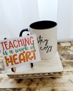 two coffee mugs sitting next to each other on top of a wooden tray with magnets