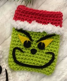 a crocheted christmas ornament with a grin face on it's side