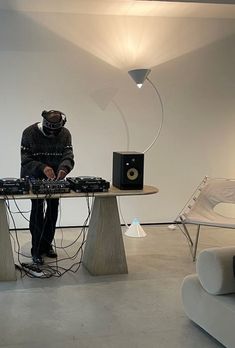 a man standing in front of a table with speakers on it