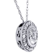 This women's solitaire pendant features a 3/4CT round brilliant cut natural diamond. The diamond is bezel set in solid 14k white gold and accented by 18 round cut natural diamonds. 1.00CT total diamond weight. An 18" 14k white gold clasp lock chain is included. Diamond Flower Pendant, Lock Chain, Solitaire Diamond Pendant, Round Halo, Trending Necklaces, Diamond Solitaire Necklace, Halo Pendant, Initial Pendant Necklace, Solitaire Necklaces