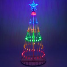 a brightly lit christmas tree with stars on it's top and lights all around the base