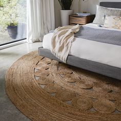 a bedroom with a bed, rug and large window looking out onto the outside patio