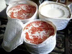 three red and white dishes sitting on top of a table next to some paper towels