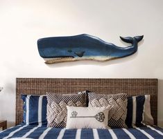 a blue whale is mounted on the wall above a bed