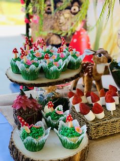 some cupcakes and strawberries are sitting on top of each other in the shape of animals