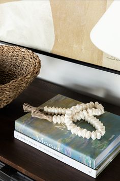 a book on a table next to a basket and lamp