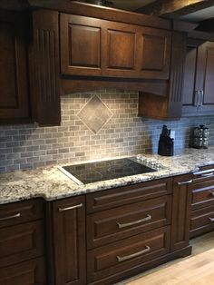 a kitchen with wooden cabinets and marble counter tops